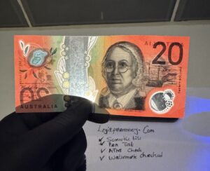 Person holding fake Australian dollars showing realistic counterfeit AUD notes with authentic security features